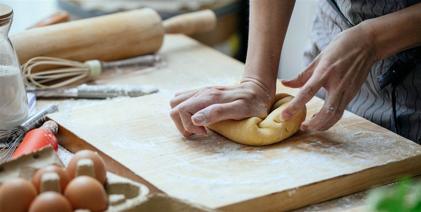 Chef working dough by hand in the kitchen while preparing a Cleveland catering order