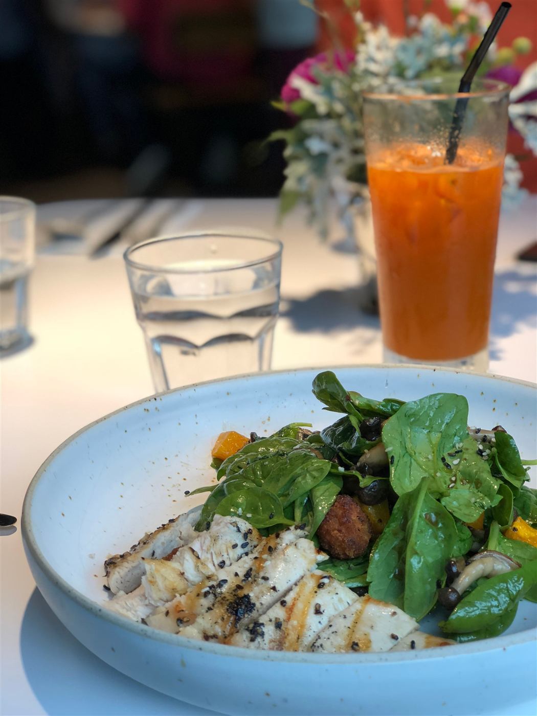 Healthy weekly meal option — grilled chicken over a spinach, mushroom and squash salad